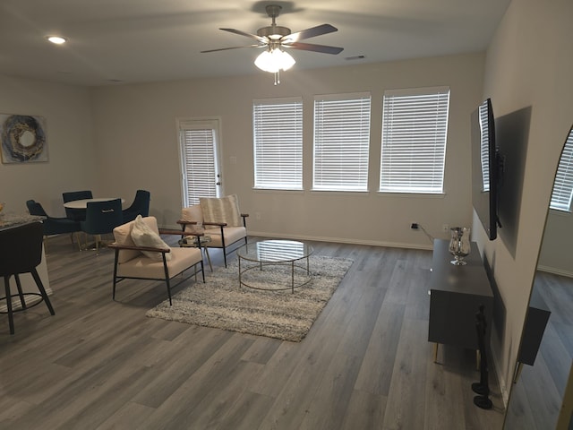 living room with dark wood-type flooring and ceiling fan