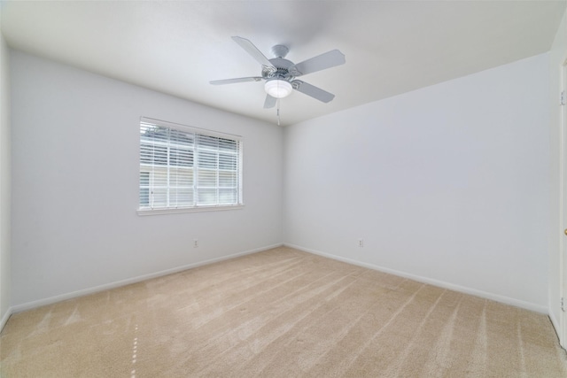 spare room with ceiling fan and light colored carpet