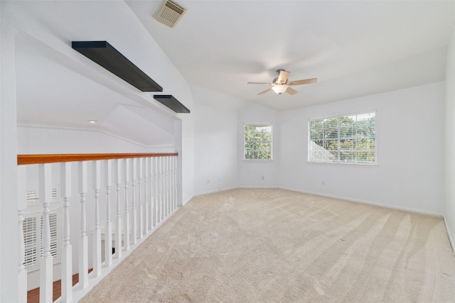 spare room featuring lofted ceiling, carpet, and ceiling fan