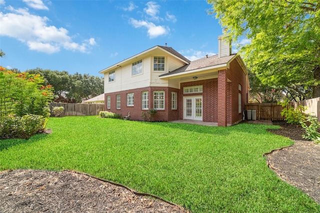 back of house featuring a yard and french doors