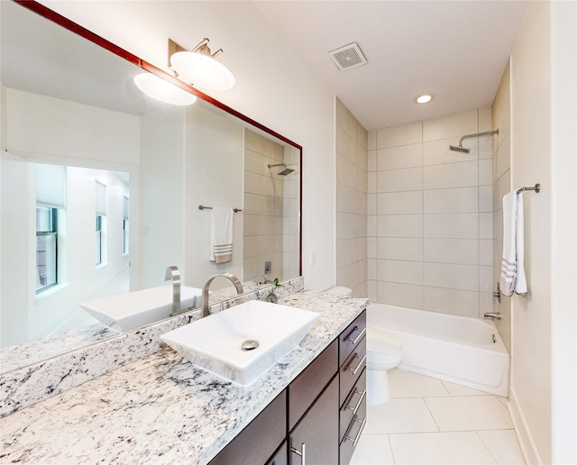 full bathroom featuring vanity, tiled shower / bath, tile patterned floors, and toilet