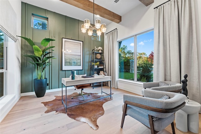 office space featuring beam ceiling, light hardwood / wood-style floors, and a notable chandelier