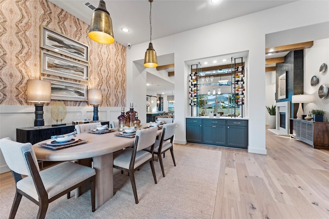 dining area featuring indoor bar and light hardwood / wood-style flooring