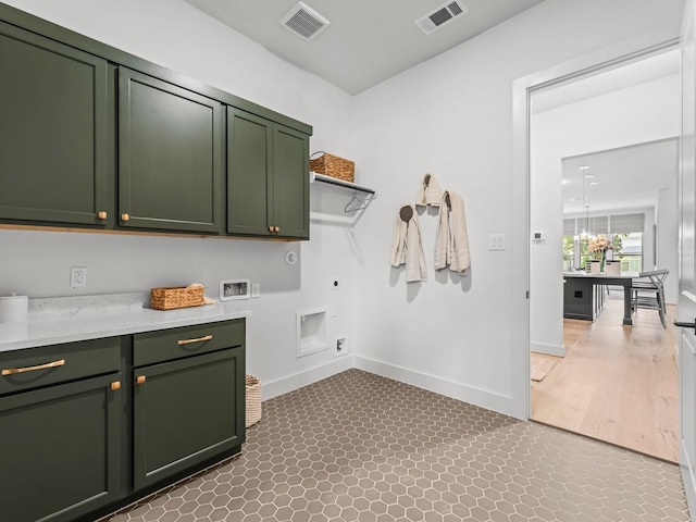 washroom featuring hookup for a washing machine, cabinets, and hookup for an electric dryer