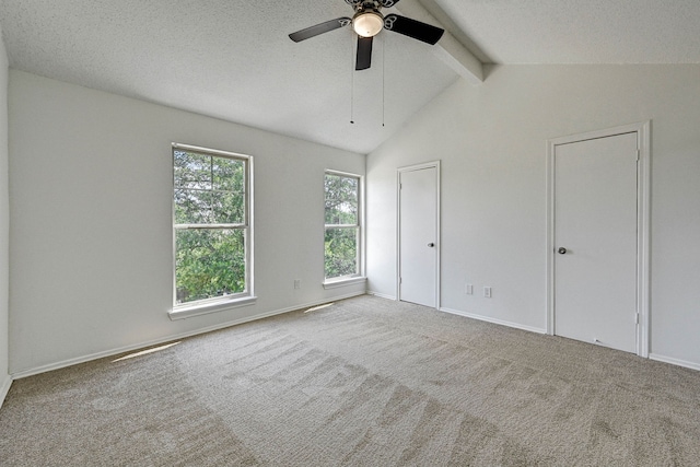 unfurnished bedroom featuring vaulted ceiling with beams, light colored carpet, a textured ceiling, and ceiling fan