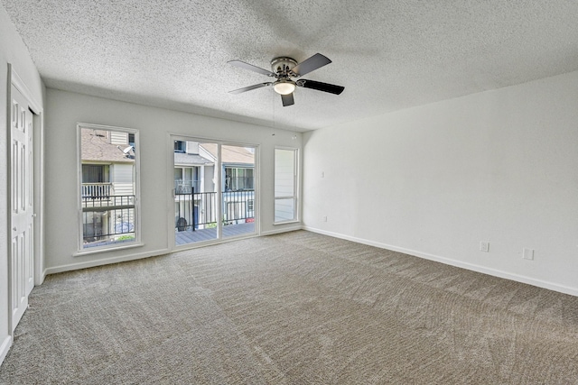 spare room featuring carpet floors, ceiling fan, a textured ceiling, and baseboards