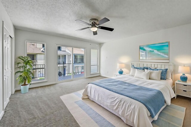 bedroom featuring a textured ceiling, carpet floors, baseboards, and access to exterior