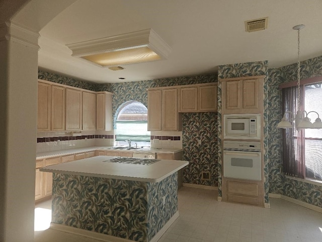 kitchen featuring light brown cabinets, a center island, sink, and white appliances