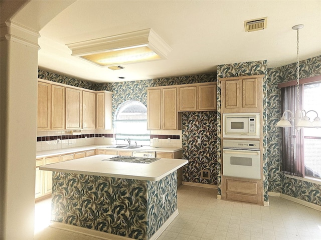 kitchen with a healthy amount of sunlight, a kitchen island, sink, and white appliances