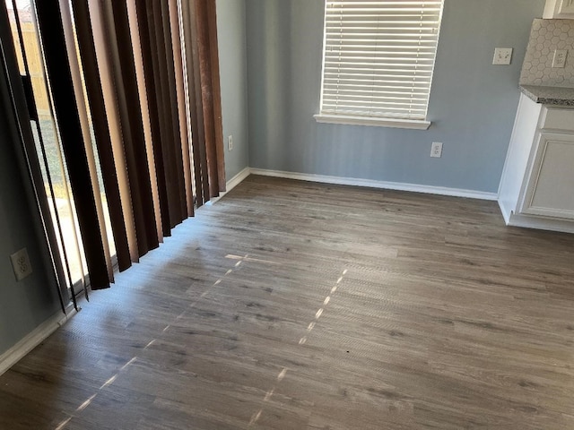 unfurnished dining area with dark hardwood / wood-style flooring and plenty of natural light