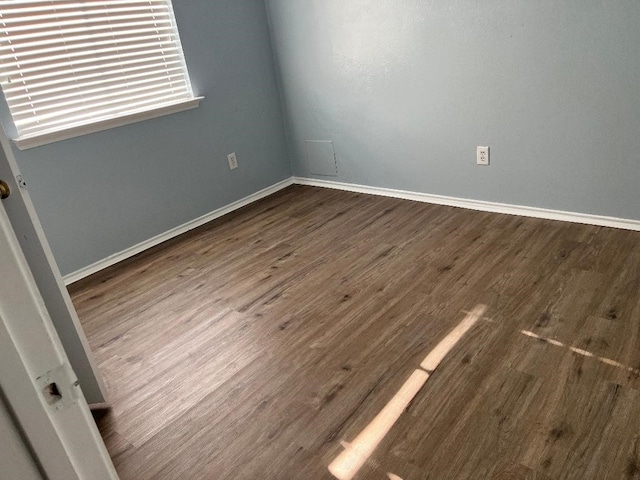 empty room with dark hardwood / wood-style flooring