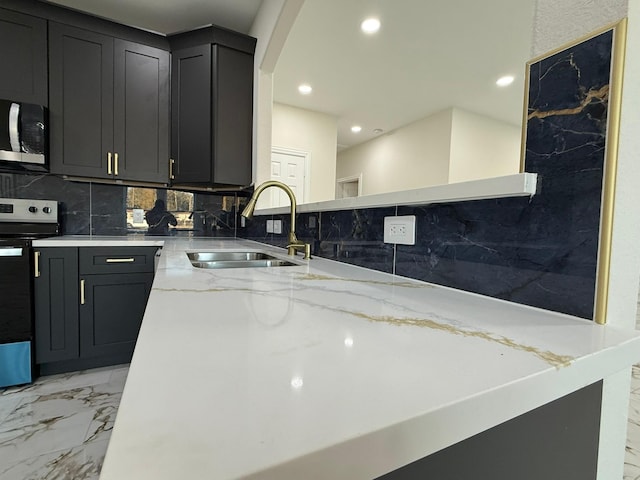 kitchen featuring light stone counters, appliances with stainless steel finishes, sink, and decorative backsplash