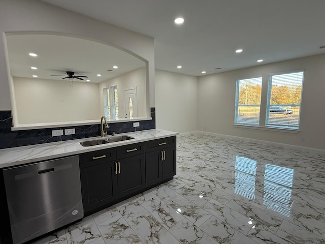 kitchen featuring dishwasher, sink, backsplash, ceiling fan, and light stone counters