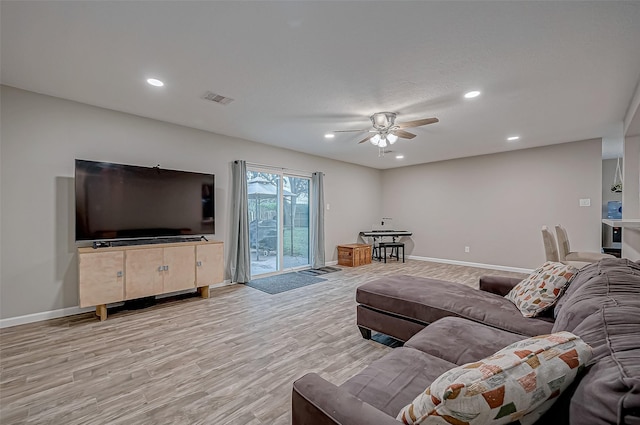 living room with light hardwood / wood-style flooring and ceiling fan