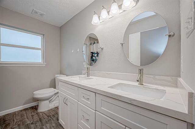 bathroom with vanity, hardwood / wood-style flooring, toilet, and a textured ceiling