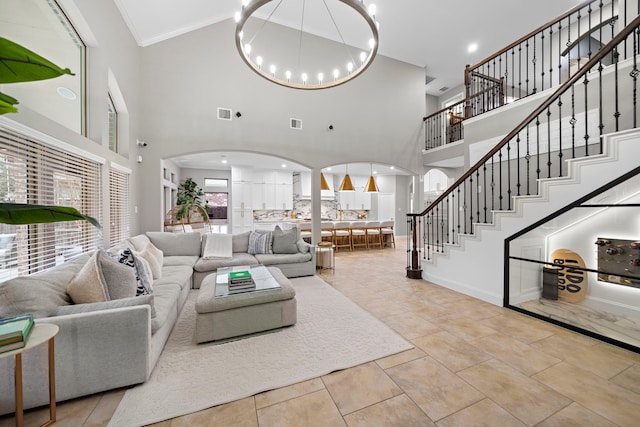 tiled living room with an inviting chandelier, crown molding, and a high ceiling