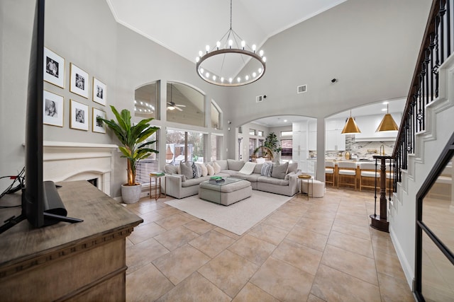 living room featuring ornamental molding, ceiling fan with notable chandelier, a high ceiling, and light tile patterned floors