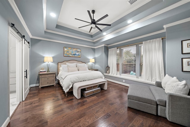 bedroom with crown molding, ceiling fan, dark hardwood / wood-style floors, a tray ceiling, and a barn door