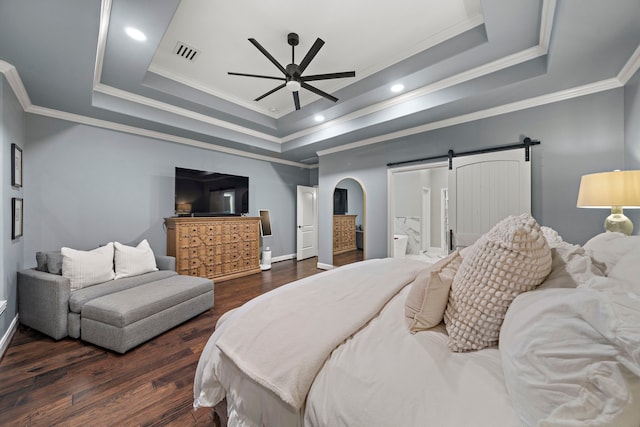 bedroom with crown molding, ceiling fan, dark hardwood / wood-style floors, a barn door, and a raised ceiling