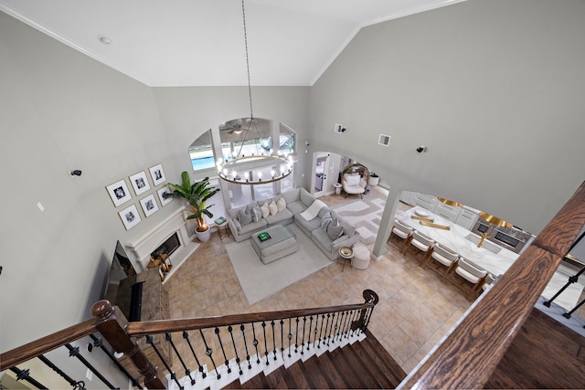 living room with an inviting chandelier, wood-type flooring, crown molding, and high vaulted ceiling