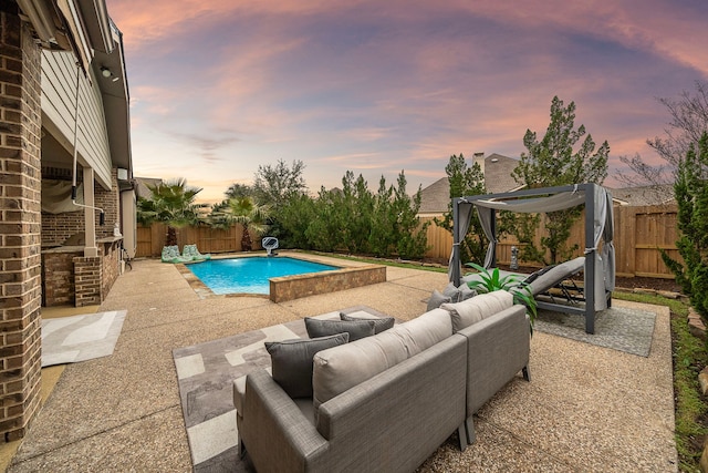 pool at dusk featuring a patio area and outdoor lounge area