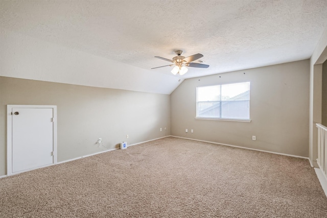 additional living space featuring ceiling fan, lofted ceiling, carpet floors, and a textured ceiling