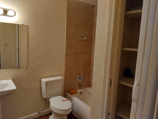 bathroom with toilet and tiled shower / bath combo