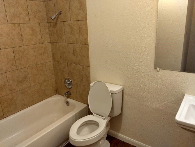 full bathroom featuring tiled shower / bath, sink, and toilet