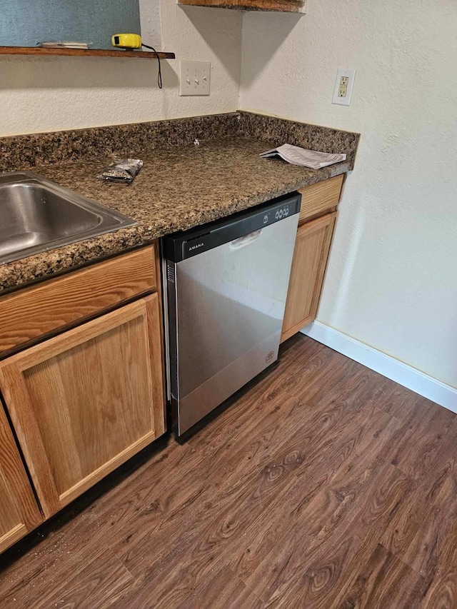 kitchen featuring dark stone counters, dark hardwood / wood-style floors, and dishwasher