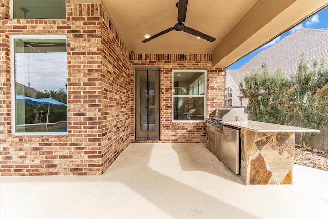 view of patio featuring ceiling fan, an outdoor kitchen, and area for grilling