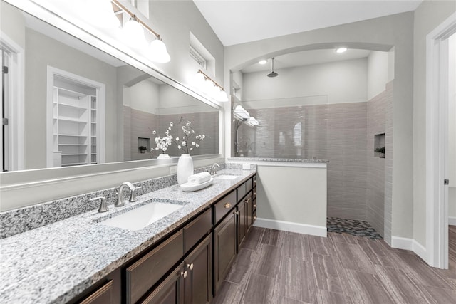 bathroom with vanity and a tile shower