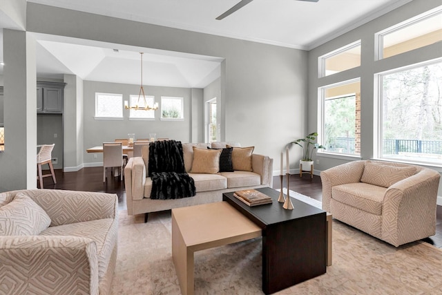 living room with crown molding, ceiling fan with notable chandelier, and light hardwood / wood-style flooring