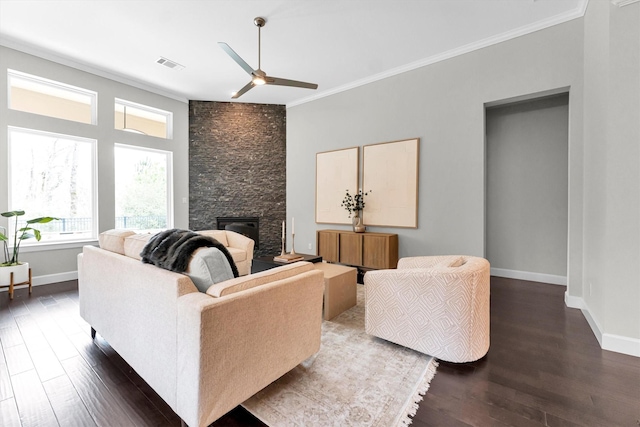 living room with crown molding, dark hardwood / wood-style floors, ceiling fan, and a fireplace