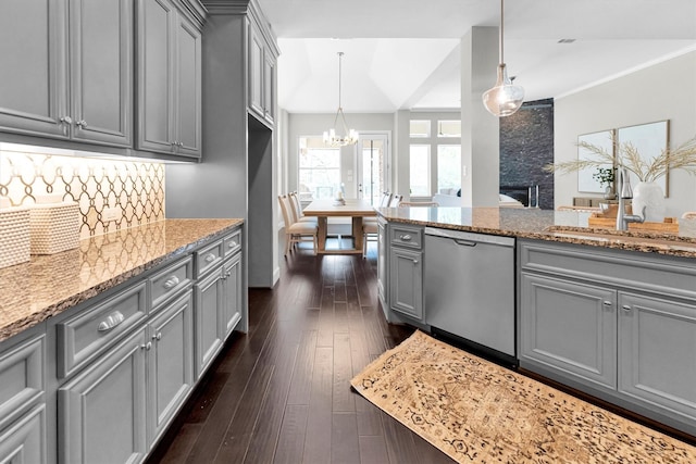 kitchen featuring pendant lighting, stainless steel dishwasher, gray cabinets, and sink