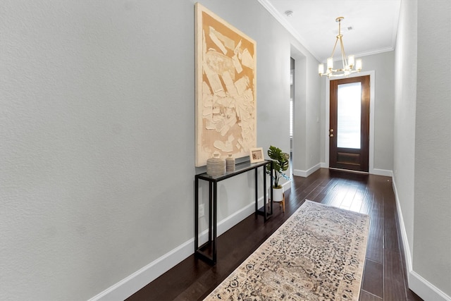 entryway with dark hardwood / wood-style flooring, crown molding, and a chandelier