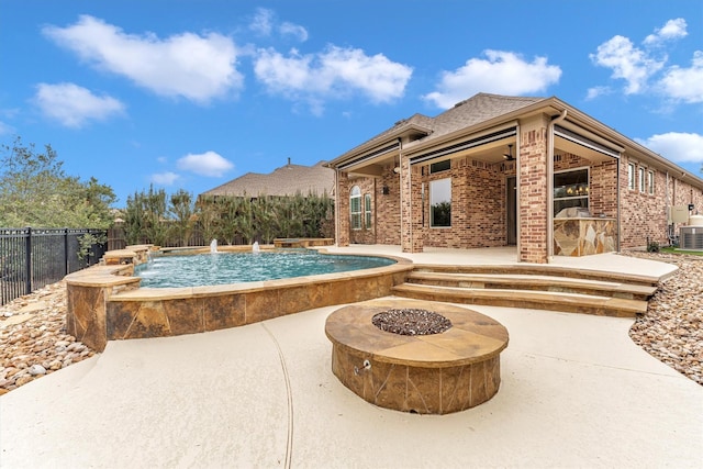 view of swimming pool featuring a patio, a fire pit, pool water feature, and ceiling fan