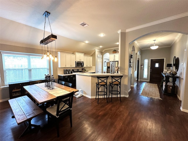 dining area with ornamental molding and dark hardwood / wood-style flooring