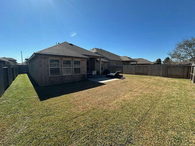 rear view of property featuring a lawn and a patio