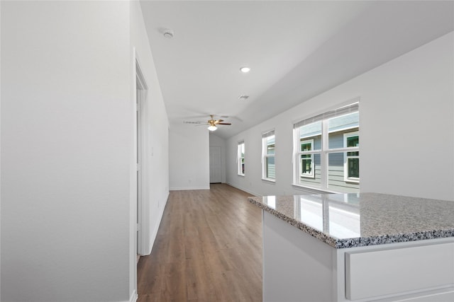 unfurnished living room featuring lofted ceiling, hardwood / wood-style floors, and ceiling fan