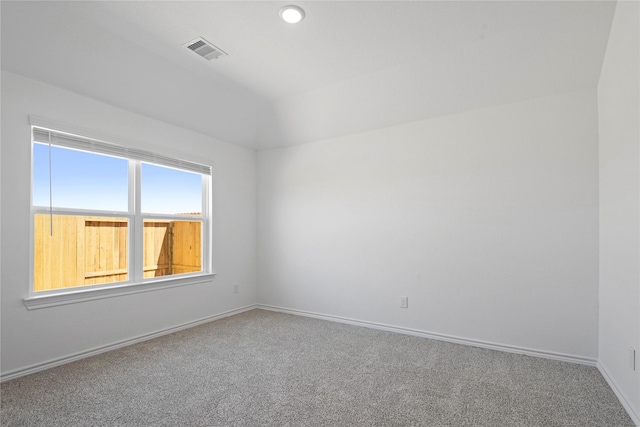 carpeted spare room with lofted ceiling