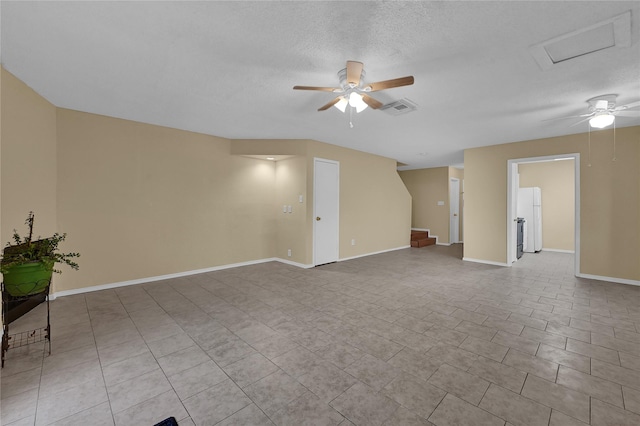 tiled spare room featuring a textured ceiling and ceiling fan