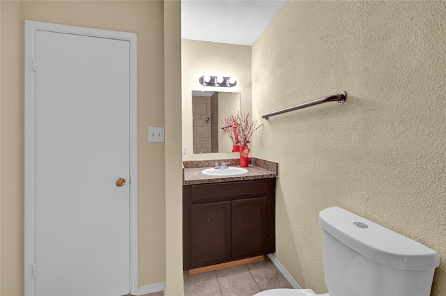 bathroom featuring vanity, tile patterned floors, and toilet