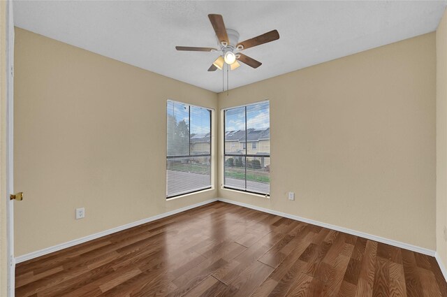 empty room featuring ceiling fan and dark hardwood / wood-style flooring