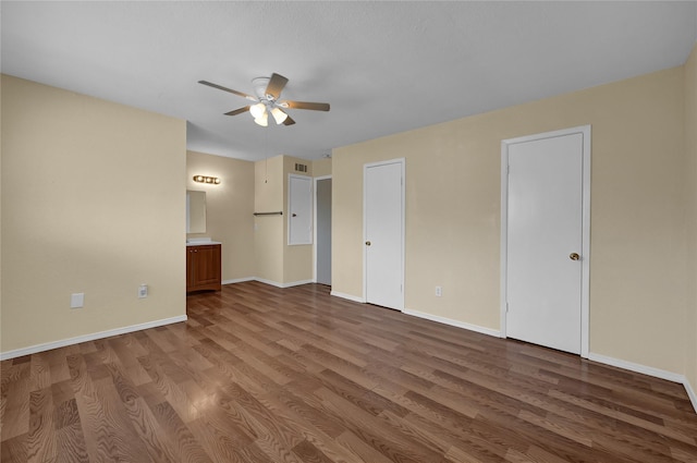 unfurnished bedroom with hardwood / wood-style flooring, ceiling fan, and ensuite bath