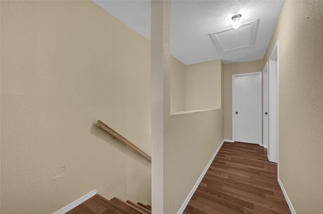 hall with dark hardwood / wood-style floors and a textured ceiling