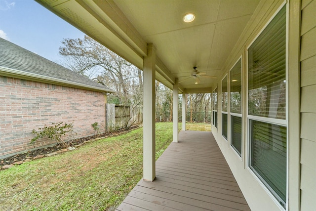 wooden terrace featuring a lawn and ceiling fan