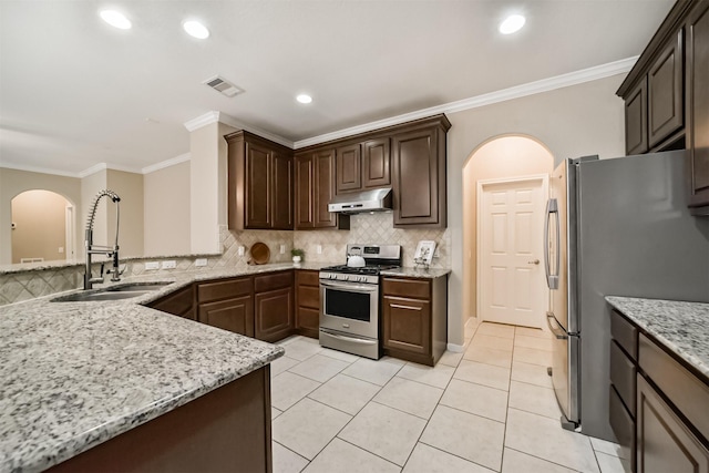 kitchen with light stone counters, appliances with stainless steel finishes, and dark brown cabinets