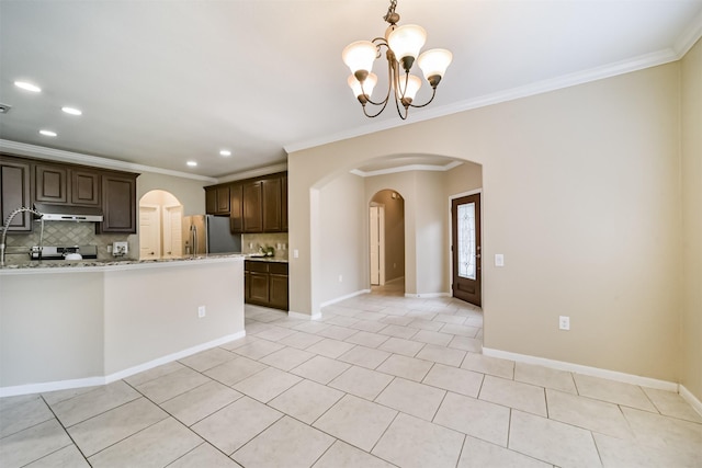 kitchen featuring tasteful backsplash, light stone counters, dark brown cabinetry, and stainless steel fridge with ice dispenser