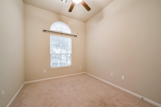 empty room featuring lofted ceiling, ceiling fan, and carpet flooring