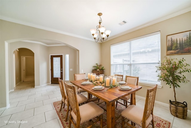 tiled dining space with ornamental molding and a chandelier